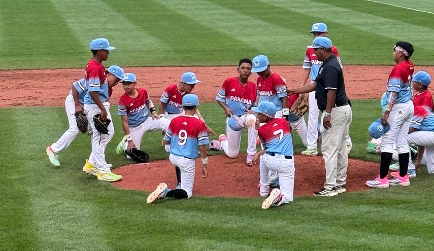 Los jugadores del equipo de Panamá se arrodillan en la lomita del Volunteer Stadium para dar gracias por la primera victoria en la Serie Mundial de Williamsport