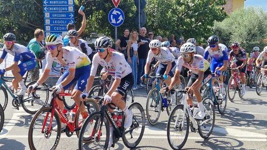 El ciclista panameño Roberto González (de blanco a la derecha) corriendo al lado el dos veces campeón del Tour de Francia, Tadej Pogacar (de blanco al centro) durante una de las pruebas la semana pasada. Foto: Cortesía/R. González