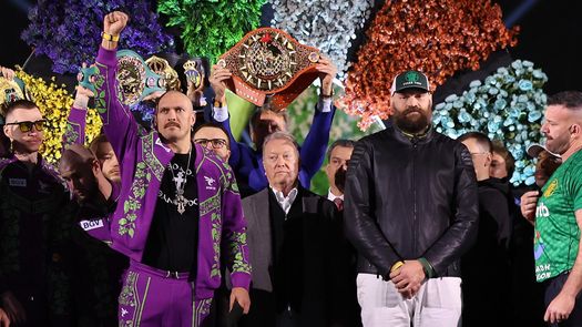 El ucraniano Oleksandr Usyk (puño en alto) y el británico Tyson Fury (con gorra) volverán a enfrentarse este sábado 21 de diciembre en Arabia Saudita. Foto: Cortesía/Matchroon Boxing